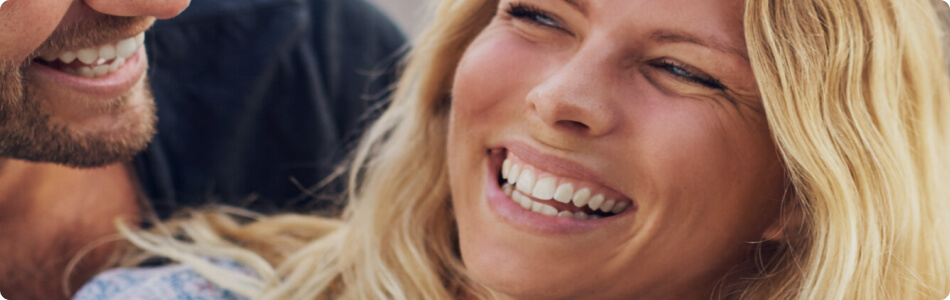 a young blonde woman smiling at her husband