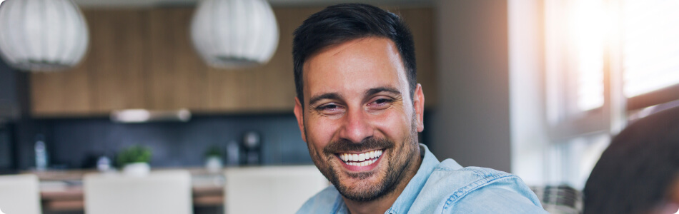 a man smiling in a blue shirt