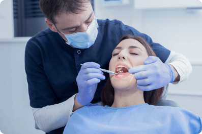 dentist scaling a woman's teeth for tartar