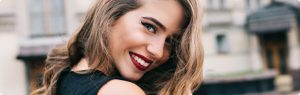 beautiful young woman with red lipstick smiling with her head slightly tilted down