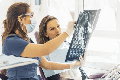 dentist showing her patient in the chair a complete dental x-ray