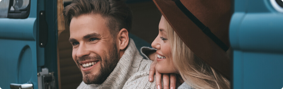 a young man and woman are sitting together and smiling at each other